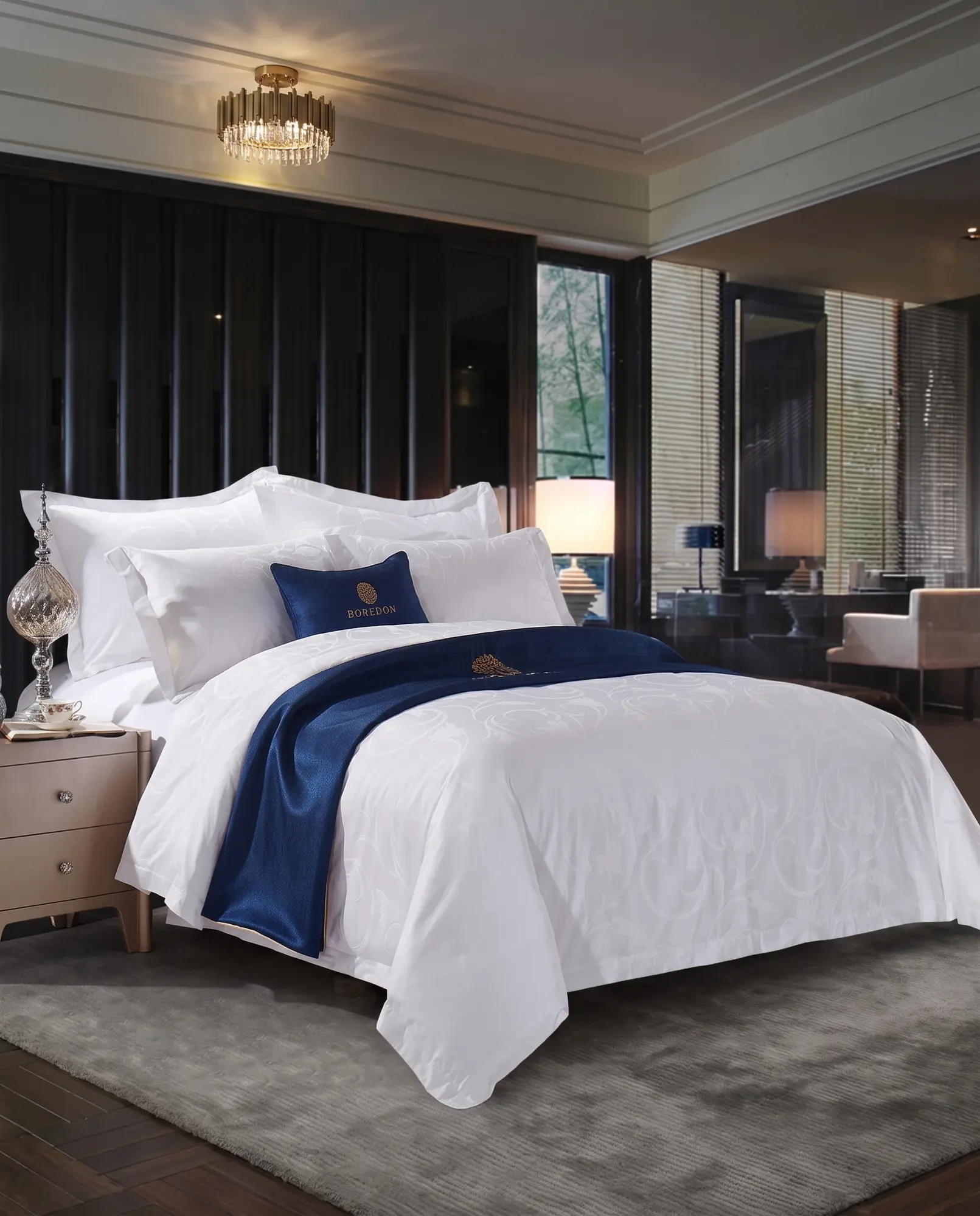 Complete hotel bed dressed with white BOREDON hospitality bedding and a navy branded accent cushion